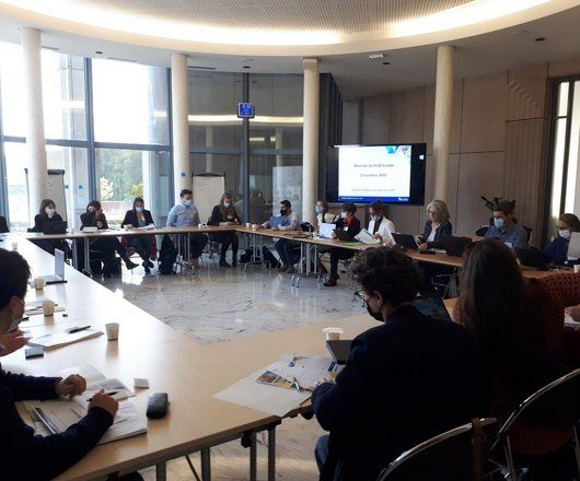 Photo de personnes assises autour d'une table en réunion